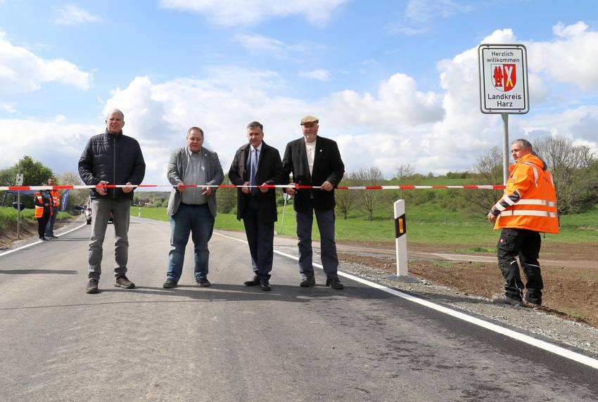 Menschen, die auf einer Straße stehen und ein Band durchschneiden