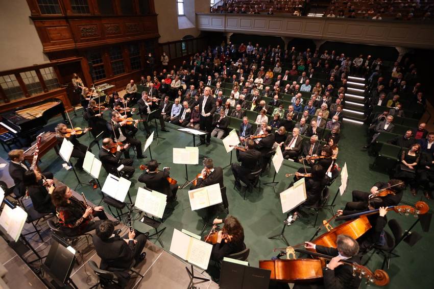 Orchester und Dirigent, im Hintergrund das Publikum Orchester und Dirigent, im Hintergrund das Publikum