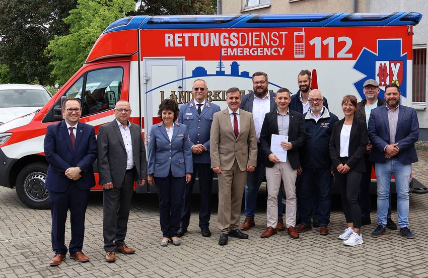 Zwöf Personen inklusive Landrat Thomas Balcerowski stehen vor einem Rettungswagen. Zwöf Personen inklusive Landrat Thomas Balcerowski stehen vor einem Rettungswagen.