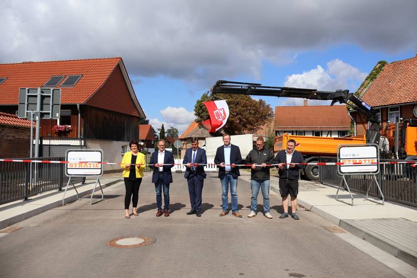 Sechs Personen stehen auf der neuen Brücke in Veckenstedt und  schneiden ein Absperrband durch, um die Brücke zu eröffnen. Sechs Personen stehen auf der neuen Brücke in Veckenstedt und  schneiden ein Absperrband durch, um die Brücke zu eröffnen.
