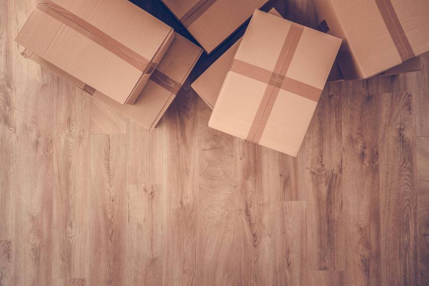 Umzugskartons, die auf einem Holzfußboden stehen.