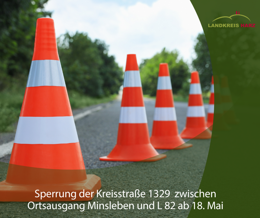 Symbolbild Straßensperrung - Absperrpylonen auf einer Straße - rechts ist ein grüber Bereich, unten auch. Im unteren Teil steht Sperrung der Kreisstraße 1329  zwischen Ortsausgang Minsleben und L 82 ab 18. Mai.