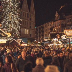 Auf dem Bild ist ein Weihnachtsmarkt mit vielen Menschen.