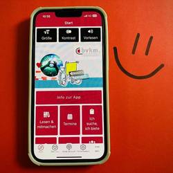 Handy auf dem die App geöffnet ist. Hintergrund ist  rot.
