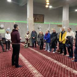 Integrationslotsen des Landkreises Harz stehen auf dem Teppichboden der Al-Rahman Moschee in Magdeburg
