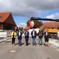 Sechs Personen stehen auf der neuen Brücke in Veckenstedt und  schneiden ein Absperrband durch, um die Brücke zu eröffnen.