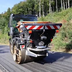 Baumaschine glättet den neuen Straßenbelag der Kreisstraße im Trecktal