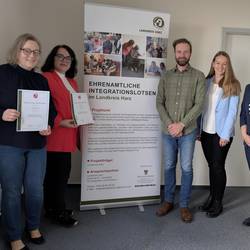 Zwei Integrationslotsen mit ihren Berufungsurkunden. und dem Team der Koordinierungsstelle.