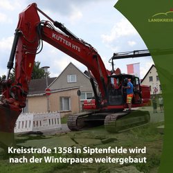 Symbolbild Straßensperrung Ein Bagger, der eine Straße aufbricht. Unten ist ein grüner Bereich mit der Aufschrift Kreisstraße 1358 in Siptenfelde wird nach der Winterpause weitergebaut.