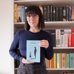 Autorin Charlotte Suhr vor einem Bücherregal. Autorin Charlotte Suhr vor einem Bücherregal.