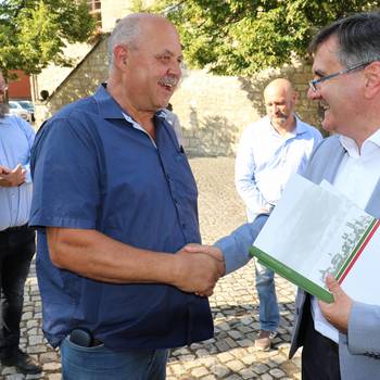 Landrat Thomas Balcerowski übergibt einen Förderbescheid für Spielplatz.