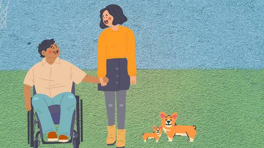 Auf dem Bild ist ein Pärchen. Der Mann sitzt im Rollstuhl und die Frau steht neben ihm. Sie haben zwei kleinen Hund dabei.