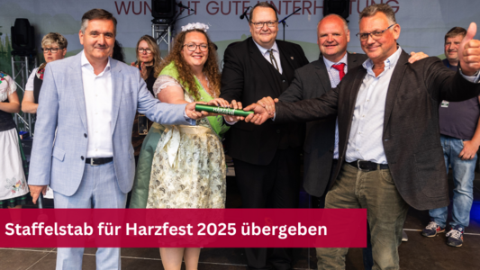 Landrat Thomas Balcerwoski überreicht den Staffelstab an Heiko Breithaupt und Frank Wieckert im Beisein weiterer Personen.