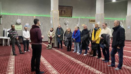 Integrationslotsen des Landkreises Harz stehen auf dem Teppichboden der Al-Rahman Moschee in Magdeburg