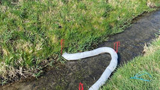 Ölsperren in einem Bach