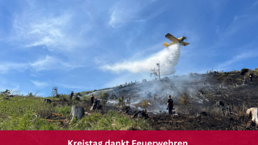 Löschflugzeug Das Löschflugzeug Hexe 1 des Landkreises Harz beim Löschvorgang über einem abgebrannten Waldstück. Auf dem Bild ist ein roter Balken mit der Aufschrift Kreistag dankt Feuerwehren.