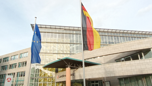 Deutschland- und Europaflagge vor dem Landkreisgebäude der Schwanebecker Straße Deutschland- und Europaflagge vor dem Landkreisgebäude der Schwanebecker Straße. Auf dem Foto ist ein roter Balken mit der Aufschrift