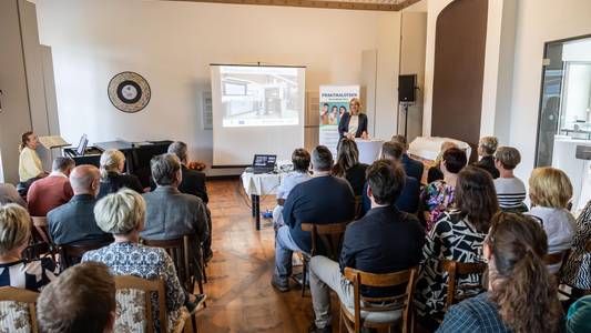 Romy Stühff, Teamleiterin für Berufs- und Studienberatung der Agentur für Arbeit Sachsen-Anhalt West steht vor vielen Personen, die auf Stühlen vor ihr sitzen.