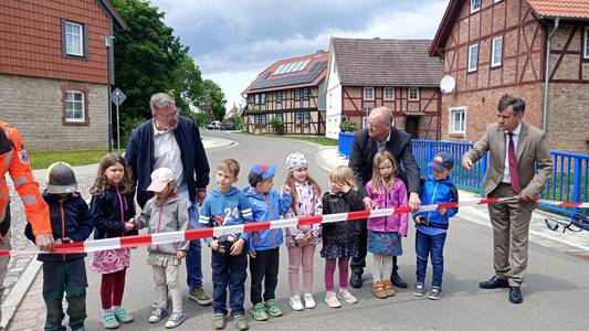 Kinder und Landrat Balcerowski schneiden ein Absperrband durch, um die neue Brücke über den Eckerngraben freizugeben. Kinder und Landrat Balcerowski schneiden ein Absperrband durch, um die neue Brücke über den Eckerngraben freizugeben.
