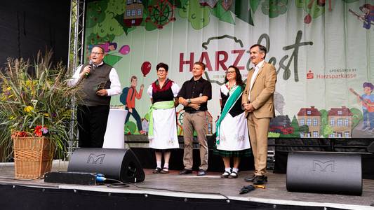 Harzfest 2025 © Marvin Mikulla Bürgermeister Heiko Breithaupt, Landrat Thomas Balcerowski und weitere Personen auf der Bühne beim Harzfest in Hüttenrode.