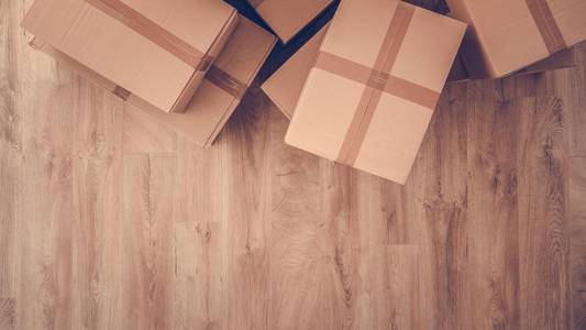 Umzugskartons, die auf einem Holzfußboden stehen.