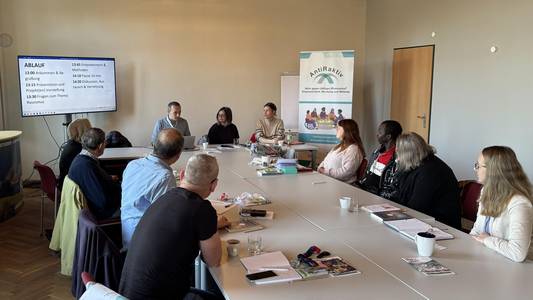 Mehrere Personen sitzen an Tischen in einem Schulungsraum