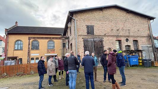 Vor dem Alten E-Werk in Blankenburg hat sich eine kleine Gruppe Menschen versammelt, die miteinander reden.