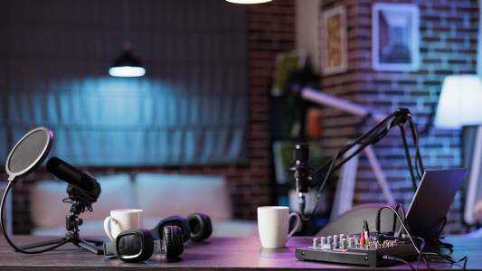 Keine Menschen an einem leeren Schreibtisch mit Aufnahmetechnik und zwei Podcast-Mikrofonen mit zwei Kaffetassen an den Arbeitsplätzen